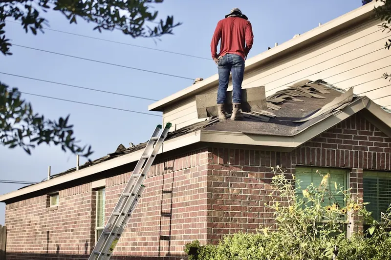 Professional roofer working on a residential roof in Burmont